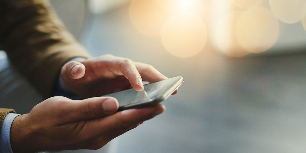 man holding phone moneyplus man holding phone save money on your phone contract