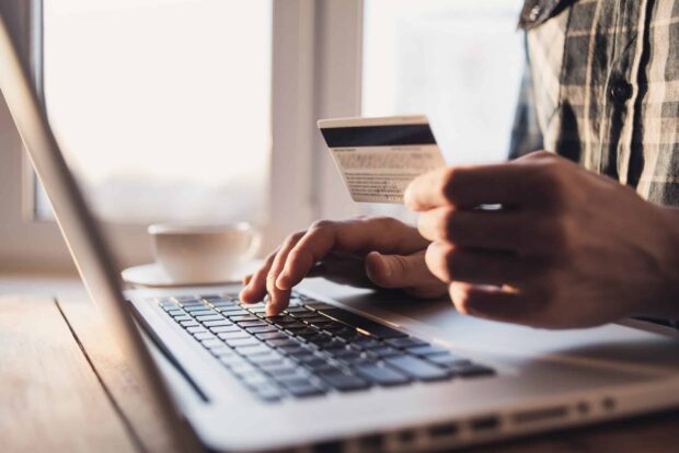 Man,Holding,Credit,Card,And,Using,Laptop.,Businessman,Or,Entrepreneur person with credit card