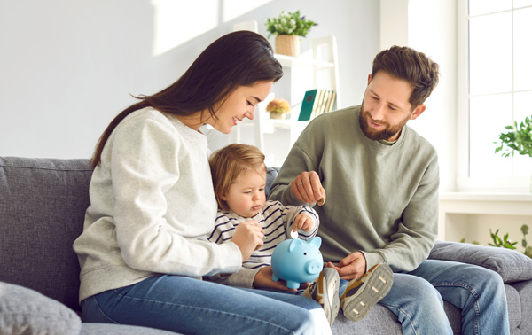 Image of a man and woman sitting on the sofa with their toddler.