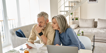 man and woman sitting at table looking at paperwork