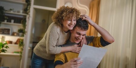 What-happens-at-the-end-of-an-IVA_-Feature Woman hugging man reading letter and smiling
