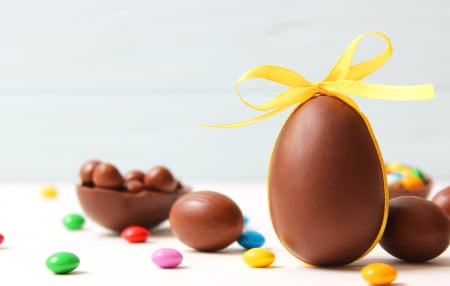An image of plain milk chocolate Easter eggs with yellow bows and different coloured smarties 