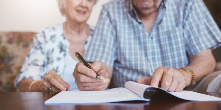 Can-an-IVA-take-my-inheritance-feature An elderly couple writing in a booklet