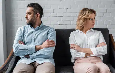 Who is responsible for debt after a separation (feature) Man and woman separated on a sofa