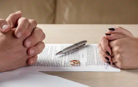 Image of two pairs of hands and a piece of paper with a pen