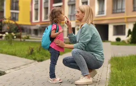 Women with her child smiling outside of a block of flats 