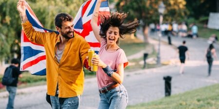 Free-UK-Festivals-and-Carnivals-feature An image of a man and a woman waving a Union Jack flag in a festival park