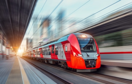 Image of a red train driving fast on the tracks
