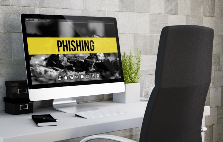An image of an iMac with the word "phishing" on the screen