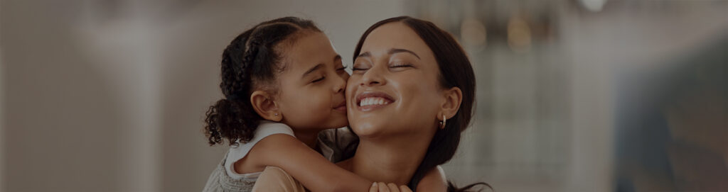 Image of a woman holding her child both smiling 