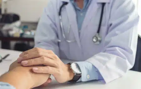 Image of a doctor holding a patients hand.