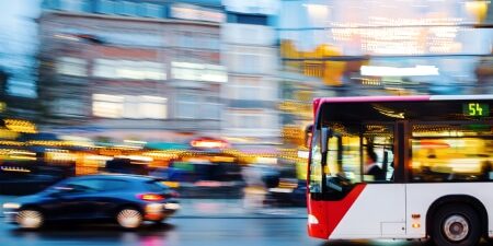 Reduce the cost of commuting_ Practical tips for managing expenses feature Image of a bus and a car travelling down a main road