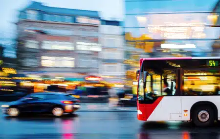 Image of a bus and a car travelling down a main road