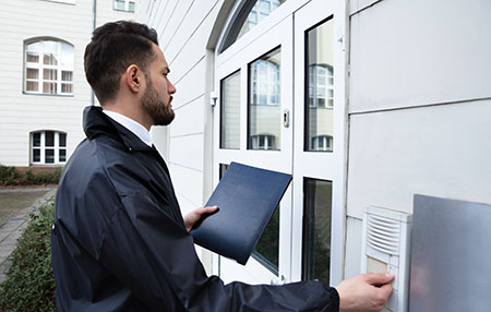 Man Standing At The Entrance Of The House Pressing The Door Bell