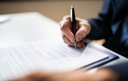 Image of someone completing a form at their desk