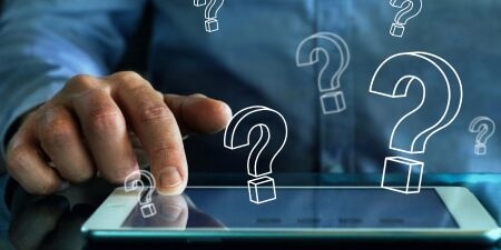 Beware of Debt Management Scams_ How To Protect Yourself feature Image of someone scrolling through their iPad with lots of floating question marks.
