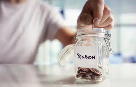 Image of a mason jar with the label "pension" on it with some coins inside.