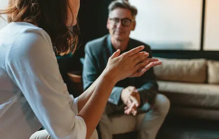 Image of a man and a woman sitting on a sofa having a chat.