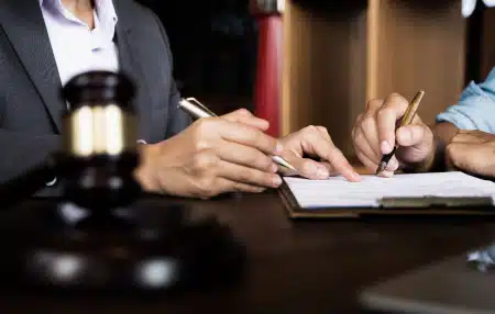 Image of two people signing a piece of paper