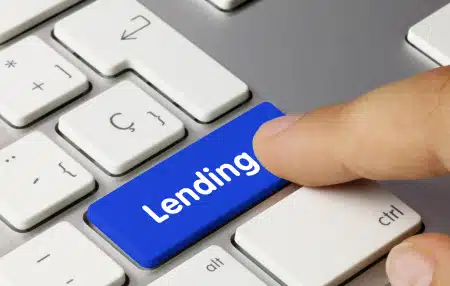 An image of someone pressing a 'lending' button on a keyboard 