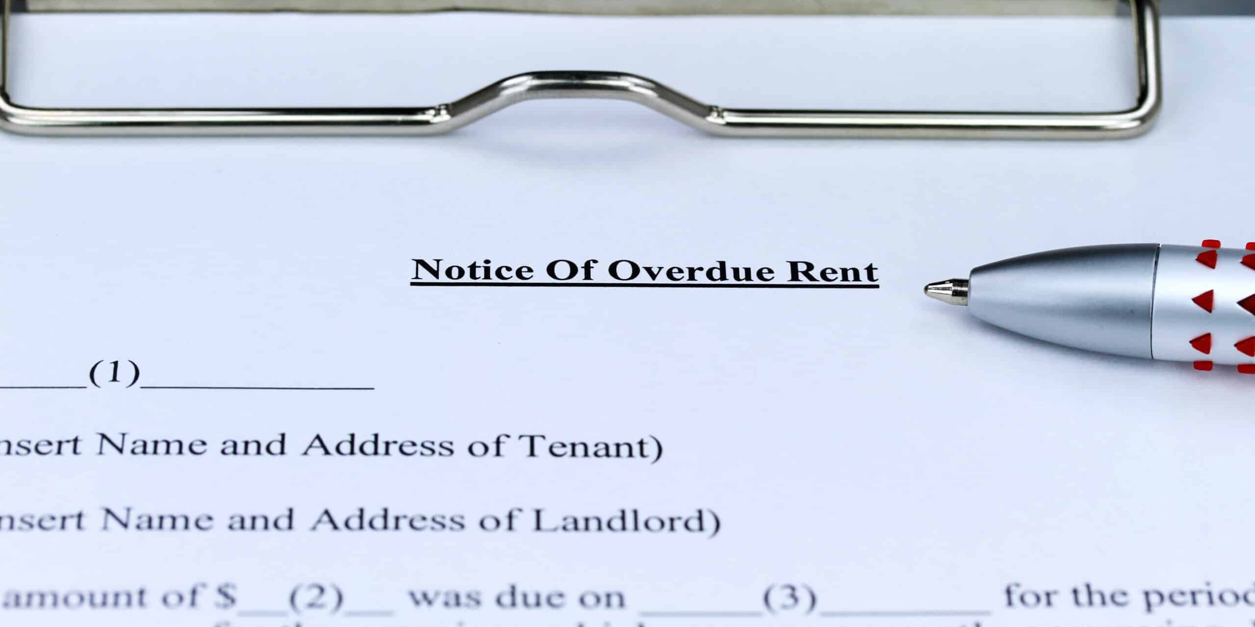 Overdue Rent Form A close-up of a 'Notice of Overdue Rent' document on a clipboard with a pen placed next to it.
