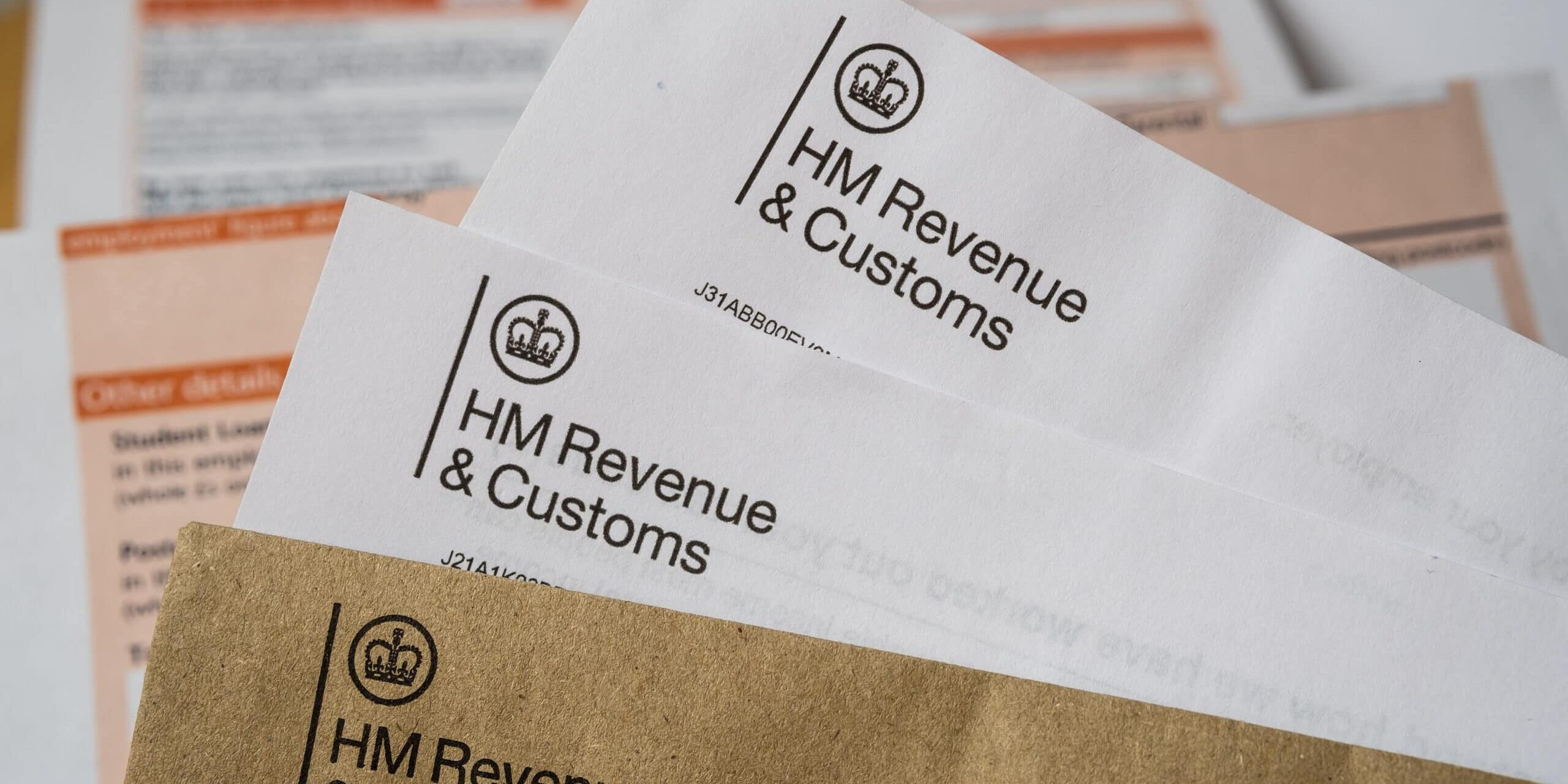 Stafford / United Kingdom – November 16 2020: HM Revenue & Customs letters seen with logos with the brown envelope. HMRC P60 form on the blurred background. Selective focus.