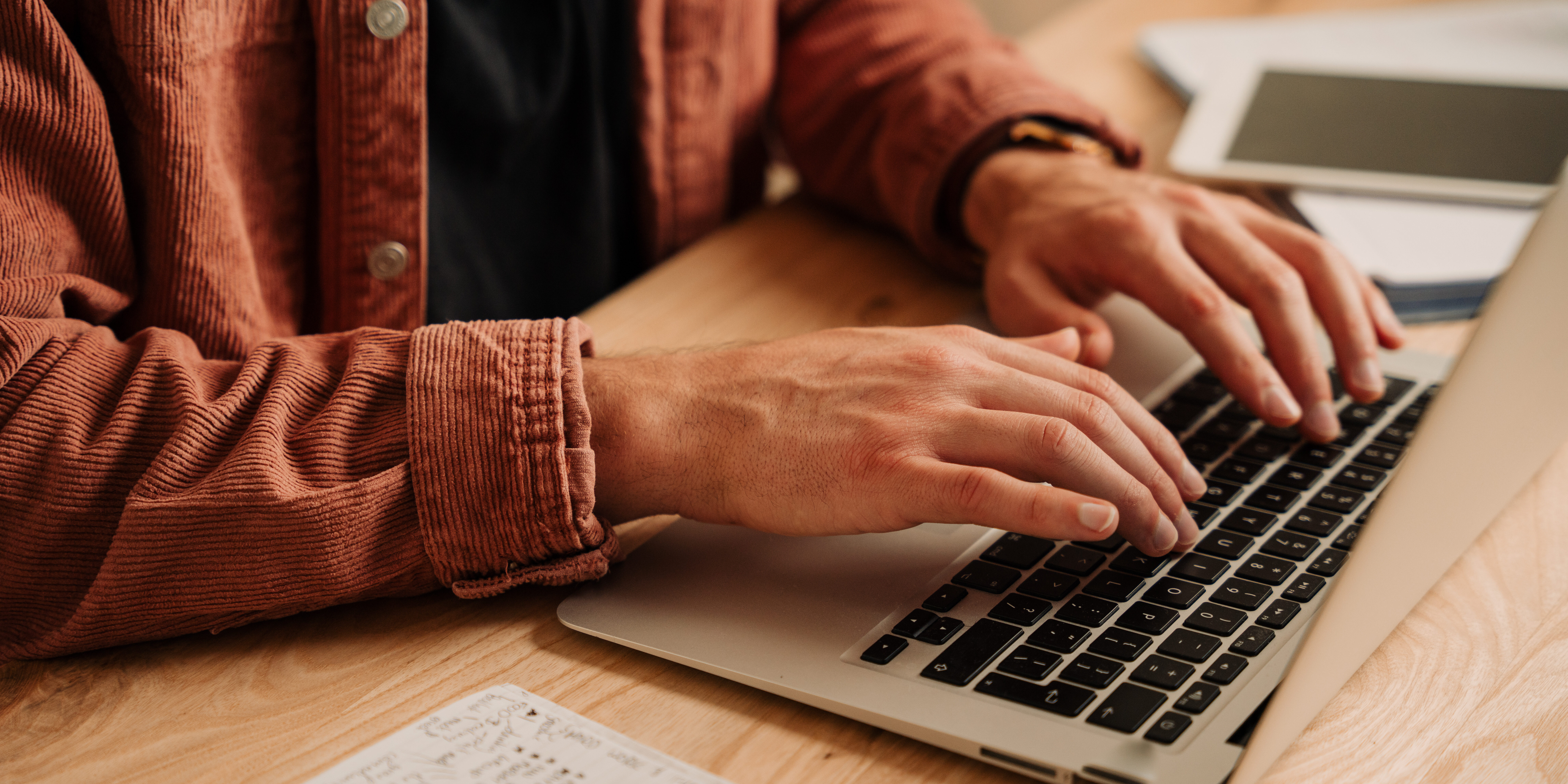 Close up caucasian male student typing on laptop at home