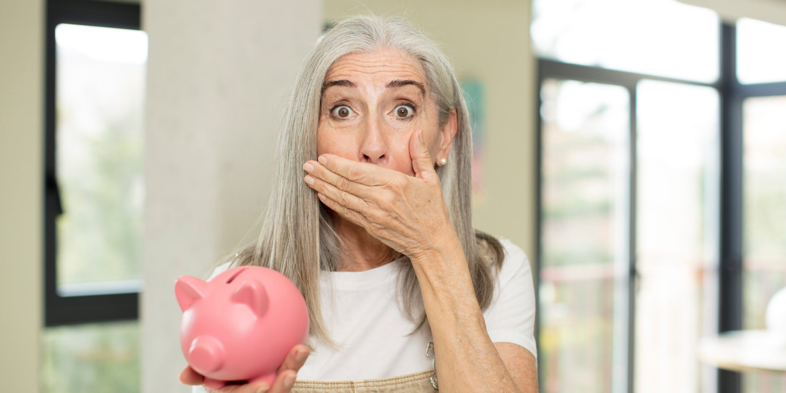 Shocked lady holding a piggybank